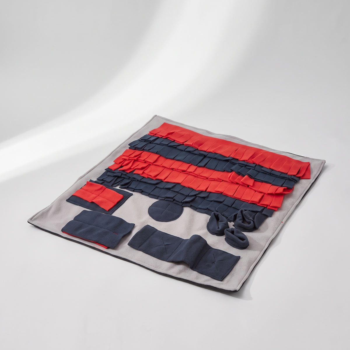 Red Snuffle Mat for Dogs Nose Work Toy, studio photo on a light grey background